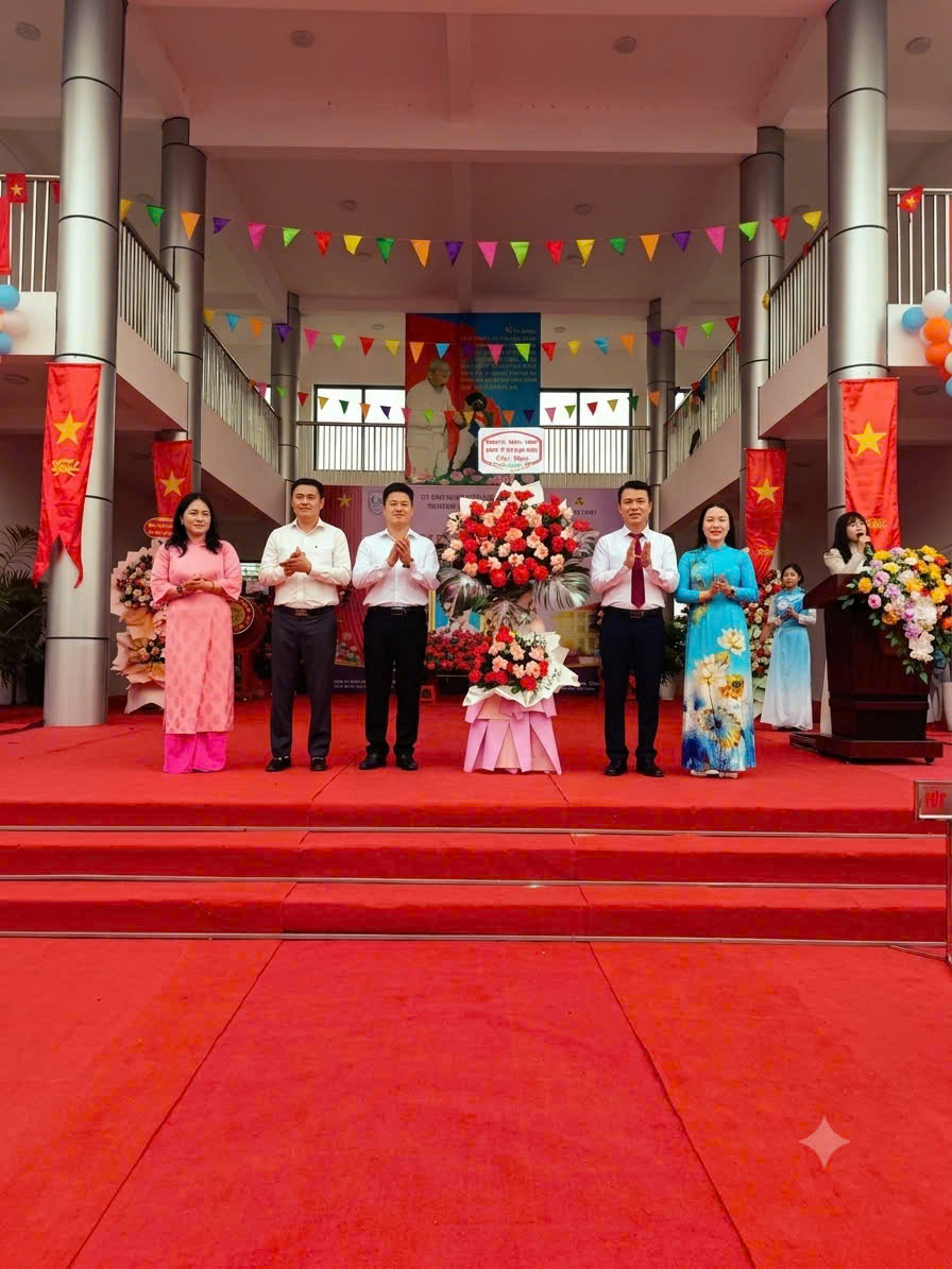 Ông Nguyễn Đăng Việt - Phó Bí thư Đảng uỷ, Chủ tịch UBND xã Bình Minh tặng hoa chúc mừng BHG cùng tập thể GV, NV và học sinh toàn trường nhân ngày khai giảng năm học 2026 - 2027