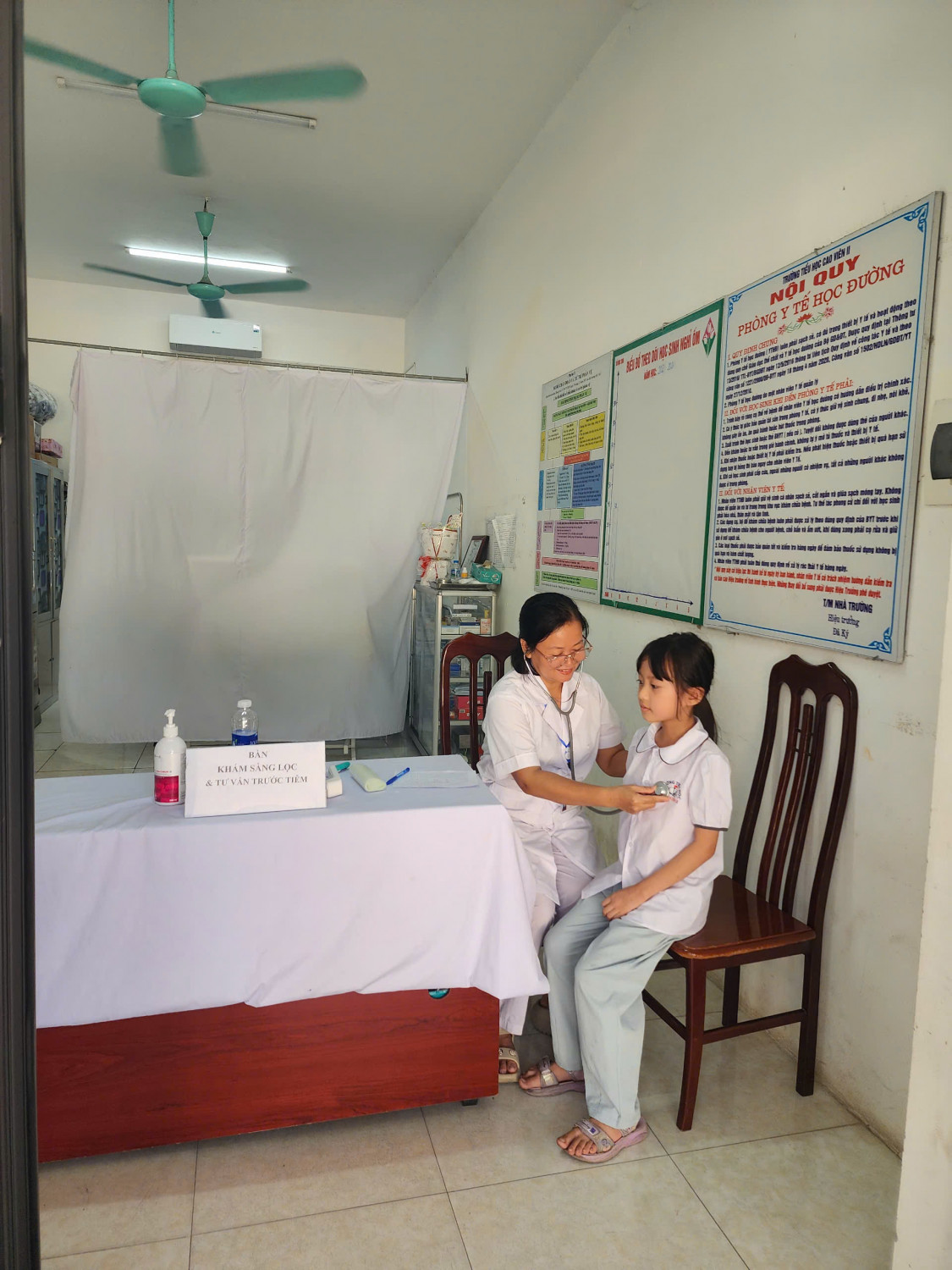 Bs Phan Thị Bẩy - Điểm trưởng Cao Viên, TYT xã Bình Minh đang khám trước khi tiêm vacxin cho học sinh